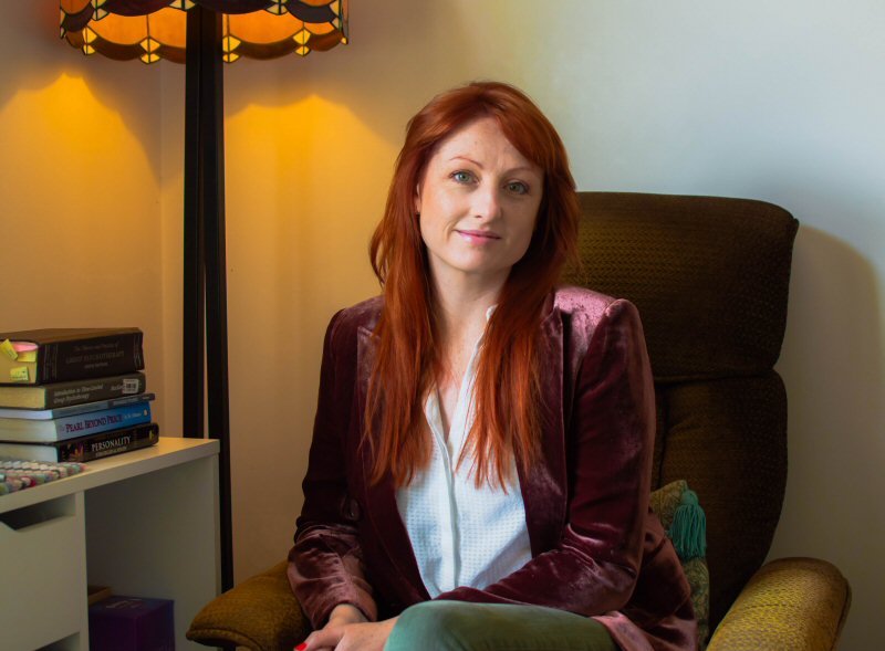 Amy Hill, psychotherapist and counsellor in Clonmel, County Tipperary, sitting in her home office, smiling at the camera.